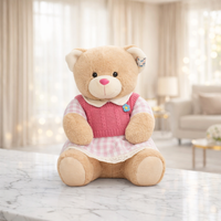Light brown teddy bear in a pink knitted vest and pink and white checked dress